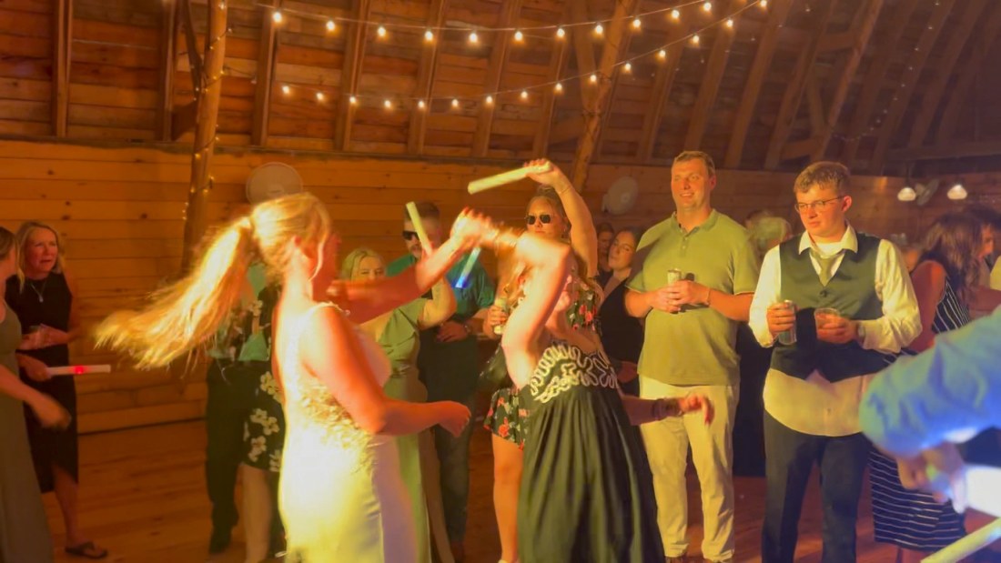 A bride spinning on the dance floor under warm string lights